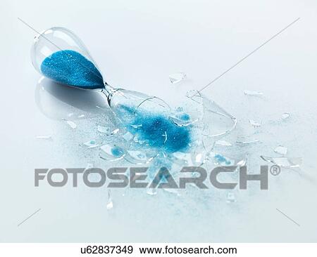 Broken glass hourglass with blue sand pouring out View Large Photo Image Stock Photo - Broken glass hourglass with blue sand pouring out. Fotosearch