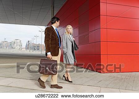 "Businessman and businesswoman, walking together, outdoors" View Large Photo Image Stock Image - "Businessman and businesswoman, walking together, outdoors". Fotosearch