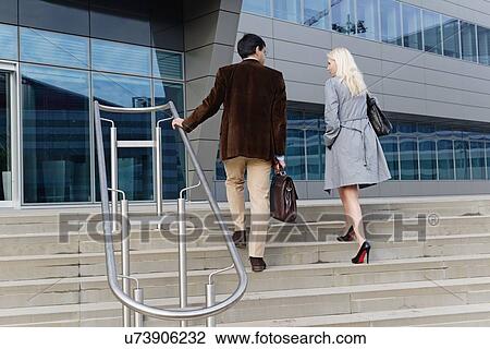 "Businessman and businesswoman, walking up steps together, rear view" View Large Photo Image Stock Image - "Businessman and businesswoman, walking up steps together, rear view". Fotosearch