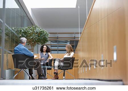 Businessman and women talking at conference room meeting View Large Photo Image Stock Image - Businessman and women talking at conference room meeting. Fotosearch