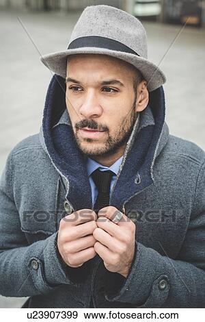 Businessman fastening his coat View Large Photo Image Stock Photo - Businessman fastening his coat. Fotosearch