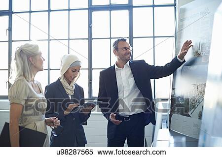 Businessman presenting ideas to business team in office View Large Photo Image Stock Photography - Businessman presenting ideas to business team in office. Fotosearch