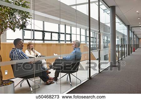 Businessmen and woman talking at conference room meeting View Large Photo Image Stock Image - Businessmen and woman talking at conference room meeting. Fotosearch