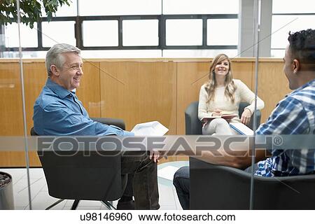 Businessmen and woman talking at team meeting in conference room View Large Photo Image Stock Image - Businessmen and woman talking at team meeting in conference room. Fotosearch