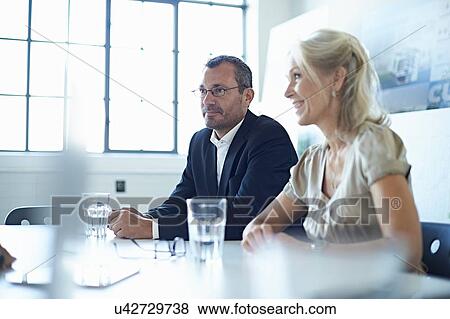 Stock Photo - Businesswoman and man at conference table in office meeting. Fotosearch