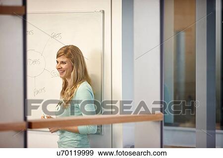 Businesswoman presenting ideas on whiteboard in office View Large Photo Image Stock Photo - Businesswoman presenting ideas on whiteboard in office. Fotosearch