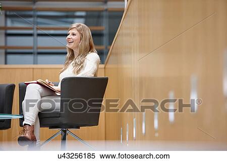 Stock Photography - Businesswoman taking notes at conference room meeting. Fotosearch