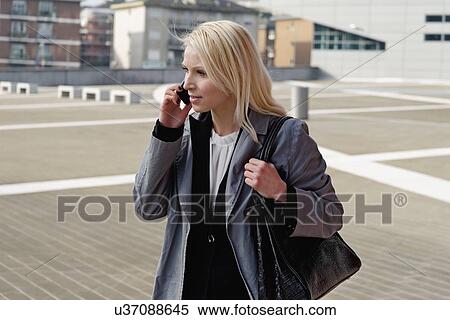 "Businesswoman, walking outdoors, using mobile phone" View Large Photo Image Stock Photography - "Businesswoman, walking outdoors, using mobile phone". Fotosearch