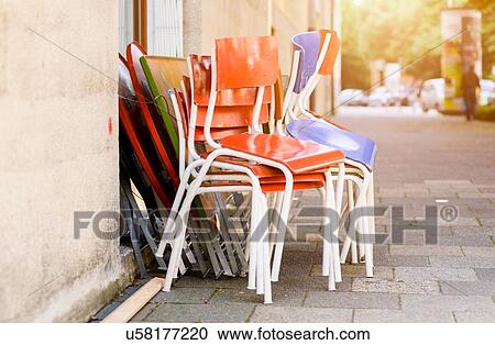 Stock Image - Chairs stacked outside building. Fotosearch