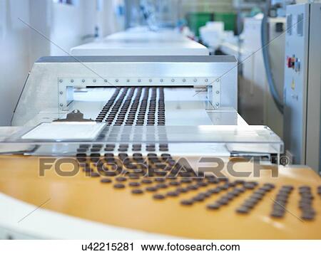 Stock Image - Chocolates on production line in chocolate factory. Fotosearch