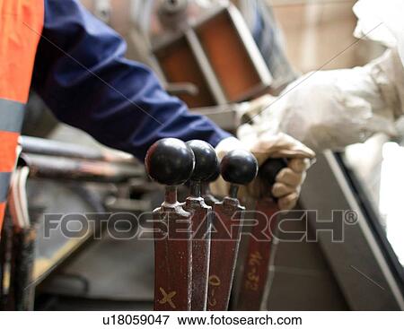 Close up of factory workers hand operating levers in concrete reinforcement factory View Large Photo Image Stock Photo - Close up of factory workers hand operating levers in concrete reinforcement factory. Fotosearch
