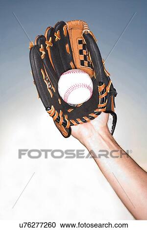 Stock Image - "Close up of female hand holding ball wearing baseball glove, Miami, Florida, USA". Fotosearch