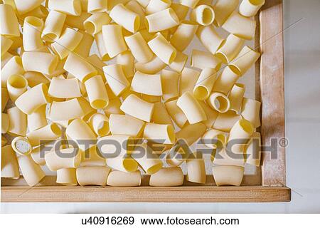 Close up of fresh pasta air drying in crate in factory View Large Photo Image Stock Photo - Close up of fresh pasta air drying in crate in factory. Fotosearch