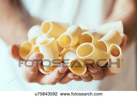Close up of male hands holding fresh pasta in factory View Large Photo Image Stock Image - Close up of male hands holding fresh pasta in factory. Fotosearch