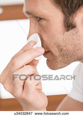 Stock Photo - Close up of man in bathroom cleansing face. Fotosearch