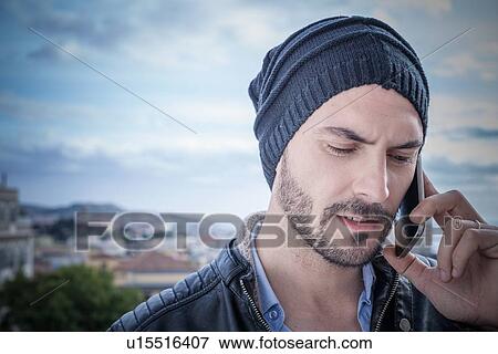 "Close up of man on rooftop talking on smartphone, Cagliari, Sardinia, Italy" View Large Photo Image Stock Photo - "Close up of man on rooftop talking on smartphone, Cagliari, Sardinia, Italy". Fotosearch