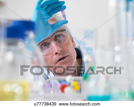 Close up of scientist holding a phial containing a DNA sample View Large Photo Image Stock Photo - Close up of scientist holding a phial containing a DNA sample. Fotosearch