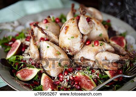 Stock Photo - Close up of serving plate of roasted wildfowl and figs. Fotosearch
