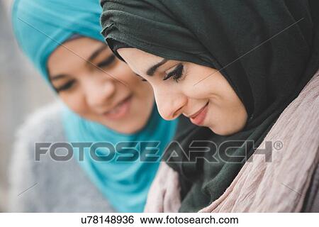 Close up of two young women wearing hijabs View Large Photo Image Stock Photograph - Close up of two young women wearing hijabs. Fotosearch