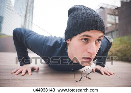 Close up of young male runner doing push ups in city View Large Photo Image Stock Image - Close up of young male runner doing push ups in city. Fotosearch