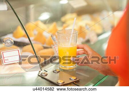 Stock Image - "Close up of young woman drinking juice at juice bar, Copacabana town, Rio De Janeiro, Brazil". Fotosearch