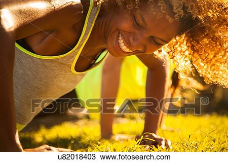 Stock Image - Close up of young woman training in park. Fotosearch