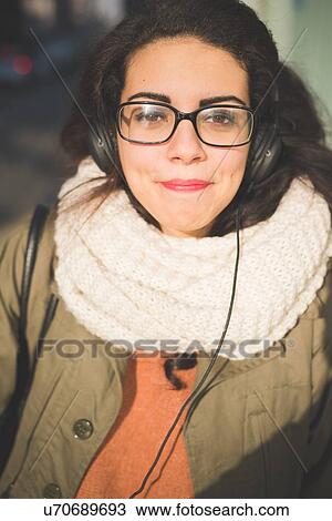 Stock Image - Close up portrait of young woman swearing spectacles on street. Fotosearch