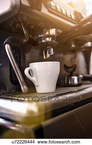 Picture - Coffee cup under coffee machine in cafe. Fotosearch