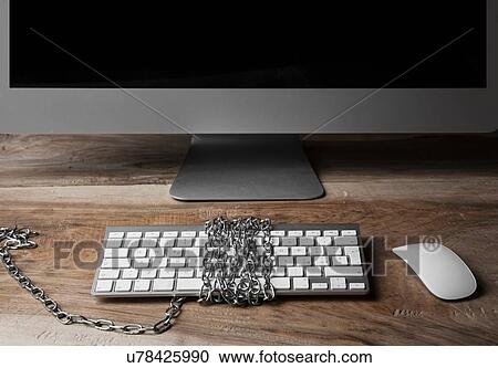 Stock Image - "Computer monitor and keyboard, chains wrapped around keyboard". Fotosearch