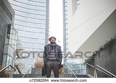 Confident mid adult businessman standing on stairway View Large Photo Image Picture - Confident mid adult businessman standing on stairway. Fotosearch