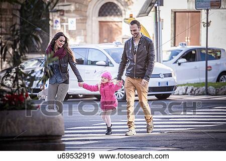 "Couple and daughter holding hands on pelican crossing, Cagliari, Sardinia, Italy" View Large Photo Image Stock Photo - "Couple and daughter holding hands on pelican crossing, Cagliari, Sardinia, Italy". Fotosearch