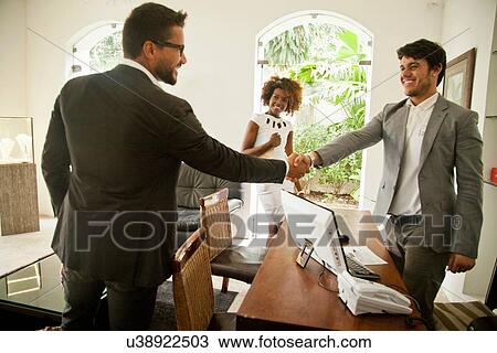 Stock Image - Couple being welcomed on arrival. Fotosearch