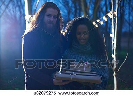 Stock Photography - Couple carrying presents to celebration in countryside. Fotosearch