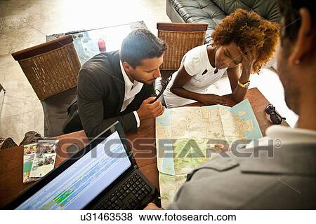 Couple checking in at hotel reception desk View Large Photo Image Stock Photo - Couple checking in at hotel reception desk. Fotosearch