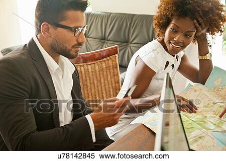 Stock Photography - Couple checking in at hotel reception desk. Fotosearch