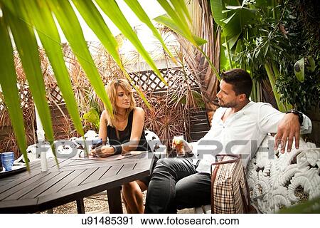 Stock Image - Couple enjoying drink on patio. Fotosearch