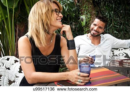 Couple enjoying drink on patio View Large Photo Image Stock Photograph - Couple enjoying drink on patio. Fotosearch