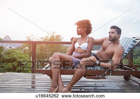 Stock Image - Couple enjoying swimming pool. Fotosearch
