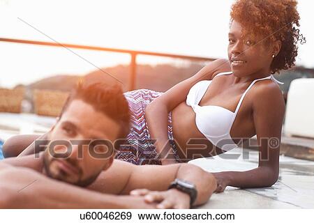 Stock Photo - Couple enjoying swimming pool. Fotosearch