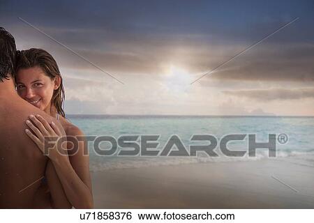 Stock Photograph - Couple hugging on beach. Fotosearch