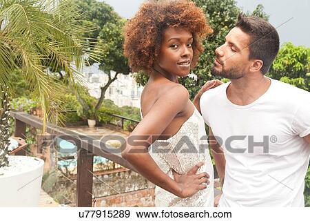 Stock Photo - Couple on terrace overlooking pool. Fotosearch