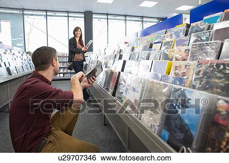Couple shopping for DVDs in electronics store View Large Photo Image Stock Photograph - Couple shopping for DVDs in electronics store. Fotosearch