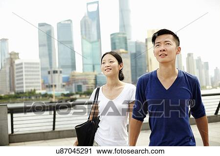 Stock Image - "Couple strolling on the waterfront, The Bund, Shanghai, China". Fotosearch
