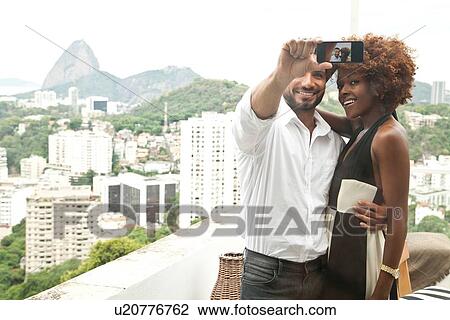 "Couple taking selfie on terrace, Sugar Loaf Mountain in background, RIo, Brazil" View Large Photo Image Stock Image - "Couple taking selfie on terrace, Sugar Loaf Mountain in background, RIo, Brazil". Fotosearch