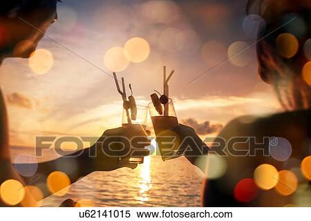 Couple toasting cocktails on vacation View Large Photo Image Stock Photography - Couple toasting cocktails on vacation. Fotosearch