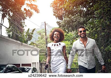 "Couple walking on street, holding hands" View Large Photo Image Stock Image - "Couple walking on street, holding hands". Fotosearch
