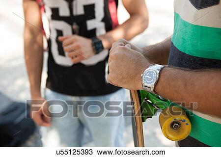Stock Image - "Cropped shot of father and son skateboarders on sidewalk, Copacabana, Rio De Janeiro, Brazil". Fotosearch