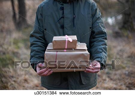 Cropped shot of gifts being carried through forest by young man View Large Photo Image Picture - Cropped shot of gifts being carried through forest by young man. Fotosearch