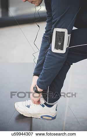 Cropped shot of young male runner fastening trainer lace View Large Photo Image Stock Photo - Cropped shot of young male runner fastening trainer lace. Fotosearch