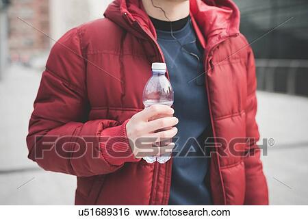Cropped shot of young man drinking water outside city office View Large Photo Image Stock Photograph - Cropped shot of young man drinking water outside city office. Fotosearch